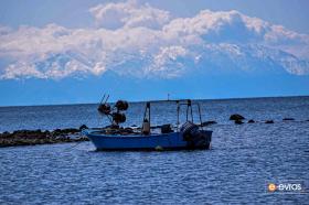 Ένα ψαροκάικο με φόντο το χιονισμένο Σάος της Σαμοθράκης
